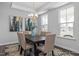 Elegant dining room with a modern chandelier, hardwood floors, and natural light from large windows at 1412 Main St, Lillington, NC 27546