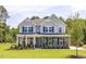 Charming two-story home featuring stone accents, gray siding, a manicured lawn, and beautiful landscaping at 1412 Main St, Lillington, NC 27546
