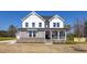 Charming two-story home featuring a welcoming front porch, brick accents, and a well-manicured lawn at 1412 Main St, Lillington, NC 27546