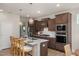 Well-equipped kitchen featuring dark wood cabinets, stainless steel appliances, a center island, and pendant lighting at 1412 Main St, Lillington, NC 27546