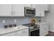 Modern kitchen features stainless steel appliances, white cabinetry, and light gray backsplash at 1412 Main St, Lillington, NC 27546