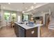 Stylish kitchen island with bar seating, stainless steel appliances, quartz countertops, and contemporary lighting at 1412 Main St, Lillington, NC 27546