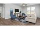Comfortable living room with modern furnishings, a ceiling fan, and large windows at 1412 Main St, Lillington, NC 27546