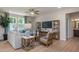 Comfortable living area with a large TV, stylish decor, wood floors, and lots of natural light from the large windows at 1412 Main St, Lillington, NC 27546
