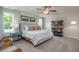Relaxing main bedroom featuring large windows, a ceiling fan, and a comfortable bed with decorative pillows at 1412 Main St, Lillington, NC 27546