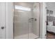 Glass enclosed shower with horizontal gray tile, a shower head, a shower handle and small window at 1412 Main St, Lillington, NC 27546