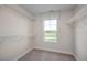 Carpeted walk-in closet with white shelving and natural light from a single window, perfect for storage at 1412 Main St, Lillington, NC 27546