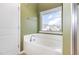Bright bathroom featuring a soaking tub and a large window with neighborhood views at 1427 Van Page Blvd, Raleigh, NC 27607