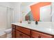 Bathroom with wooden vanity, white countertop, and decorative orange and gray painted wall at 1427 Van Page Blvd, Raleigh, NC 27607