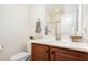 Cozy bathroom featuring a wood vanity, white countertop, and glass shower door for a clean aesthetic at 1427 Van Page Blvd, Raleigh, NC 27607