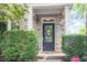 Close-up of a front door framed by green bushes and a brick facade at 1427 Van Page Blvd, Raleigh, NC 27607
