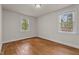 This bright bedroom features hardwood floors and two windows for natural light at 1512 Oxford Rd, Henderson, NC 27536