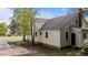Picture shows the house's back, the exterior is painted light with windows all around at 1512 Oxford Rd, Henderson, NC 27536