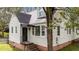 Charming home featuring a blend of siding, brick foundation, and a welcoming black front door at 1512 Oxford Rd, Henderson, NC 27536