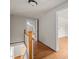 Hallway with wood floors leads to a bedroom, door open to show floors and attic-style ceiling at 1512 Oxford Rd, Henderson, NC 27536