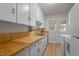Kitchen features wooden countertops and white cabinets at 1512 Oxford Rd, Henderson, NC 27536