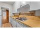 Kitchen features wooden countertops and white cabinets with view to hall and stairs at 1512 Oxford Rd, Henderson, NC 27536