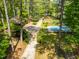 Aerial view of a property featuring a pool, a long driveway, mature trees, and a large yard at 1608 New Hill Olive Chapel Rd, Apex, NC 27502