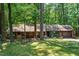 Charming home with a manicured lawn, mature trees, a wooden bench, and an attached two-car garage at 1608 New Hill Olive Chapel Rd, Apex, NC 27502