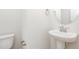 Half bathroom featuring a pedestal sink, oval mirror and modern fixtures; bright and clean design at 162 Tuskeegee Dr, Smithfield, NC 27577