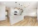Open kitchen with an island, white cabinets, pendant lighting, and stainless appliances at 162 Tuskeegee Dr, Smithfield, NC 27577