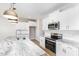 Modern kitchen features white cabinets, stainless steel appliances, granite counters and an island with pendant lighting at 162 Tuskeegee Dr, Smithfield, NC 27577