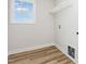 Bright laundry room with a window, wood-look flooring, shelving and modern utility hookups at 162 Tuskeegee Dr, Smithfield, NC 27577