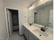Bright bathroom with double vanity, quartz countertop, undermount sinks, large mirror, and modern lighting at 188 Tuskeegee Dr, Smithfield, NC 27577