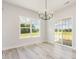 Bright dining room featuring wood floors, a modern chandelier, and sliding door access to the backyard at 188 Tuskeegee Dr, Smithfield, NC 27577