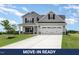 Charming two-story home features a manicured lawn, gray siding, and a bright white garage door with black hardware at 188 Tuskeegee Dr, Smithfield, NC 27577