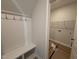 Mud room with a bench, coat hooks, and storage shelves leading to the laundry room at 188 Tuskeegee Dr, Smithfield, NC 27577
