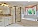 Luxurious bathroom features a large glass enclosed shower, garden tub, granite countertops, and a picturesque window at 1927 Napoli Dr, Apex, NC 27502