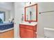 Bathroom with cherry vanity, white sink and toilet, and views into bedroom at 1927 Napoli Dr, Apex, NC 27502