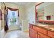 Updated bathroom features a jacuzzi tub, dark marble countertops, and a window with view of the front yard at 1927 Napoli Dr, Apex, NC 27502