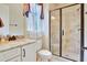 Tiled bathroom featuring a glass-enclosed shower, granite vanity, and a window with curtains for natural light at 1927 Napoli Dr, Apex, NC 27502