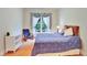 Comfortable bedroom with light wood floors, chair, and bright window views at 1927 Napoli Dr, Apex, NC 27502