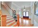 Bright foyer with hardwood floors, stairs, and a front door with glass panels at 1927 Napoli Dr, Apex, NC 27502