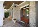 Charming front porch with brick flooring, a wooden bench, and double doors at 1927 Napoli Dr, Apex, NC 27502