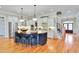 Spacious kitchen featuring white cabinets, a dark island with seating, and stainless steel appliances at 1927 Napoli Dr, Apex, NC 27502