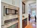 Close-up of kitchen appliances and dark cabinets with granite countertops, leading to a bright dining area at 1927 Napoli Dr, Apex, NC 27502