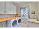 Well-lit laundry room with washer, dryer, and ample counter space at 1927 Napoli Dr, Apex, NC 27502