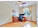 Office features hardwood floors, a ceiling fan, and large window letting in natural light at 1927 Napoli Dr, Apex, NC 27502