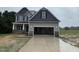 Two-story home featuring an attached two car garage, gray siding and black shutters at 202 Tuskeegee Dr, Smithfield, NC 27577