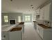 Unfinished kitchen and living area featuring a fireplace, an island, and white cabinets at 202 Tuskeegee Dr, Smithfield, NC 27577