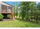 Backyard featuring a screened porch, staircase, and a view of lush trees and lake beyond at 2212 Plowridge Rd, Fuquay Varina, NC 27526