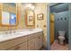 Bathroom showcasing a dual vanity, decorative wallpaper, and access to a shower at 2212 Plowridge Rd, Fuquay Varina, NC 27526