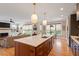 Open kitchen with a large island, stainless steel appliances, and hardwood floors at 2212 Plowridge Rd, Fuquay Varina, NC 27526
