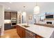 Open concept kitchen with a large island, stainless steel appliances, and hardwood floors at 2212 Plowridge Rd, Fuquay Varina, NC 27526