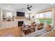 Inviting living room with a cozy fireplace, a ceiling fan, and built-in shelving at 2212 Plowridge Rd, Fuquay Varina, NC 27526