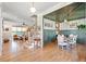 Open-concept living room with hardwood floors, dining area, staircase, and ample natural light at 2212 Plowridge Rd, Fuquay Varina, NC 27526